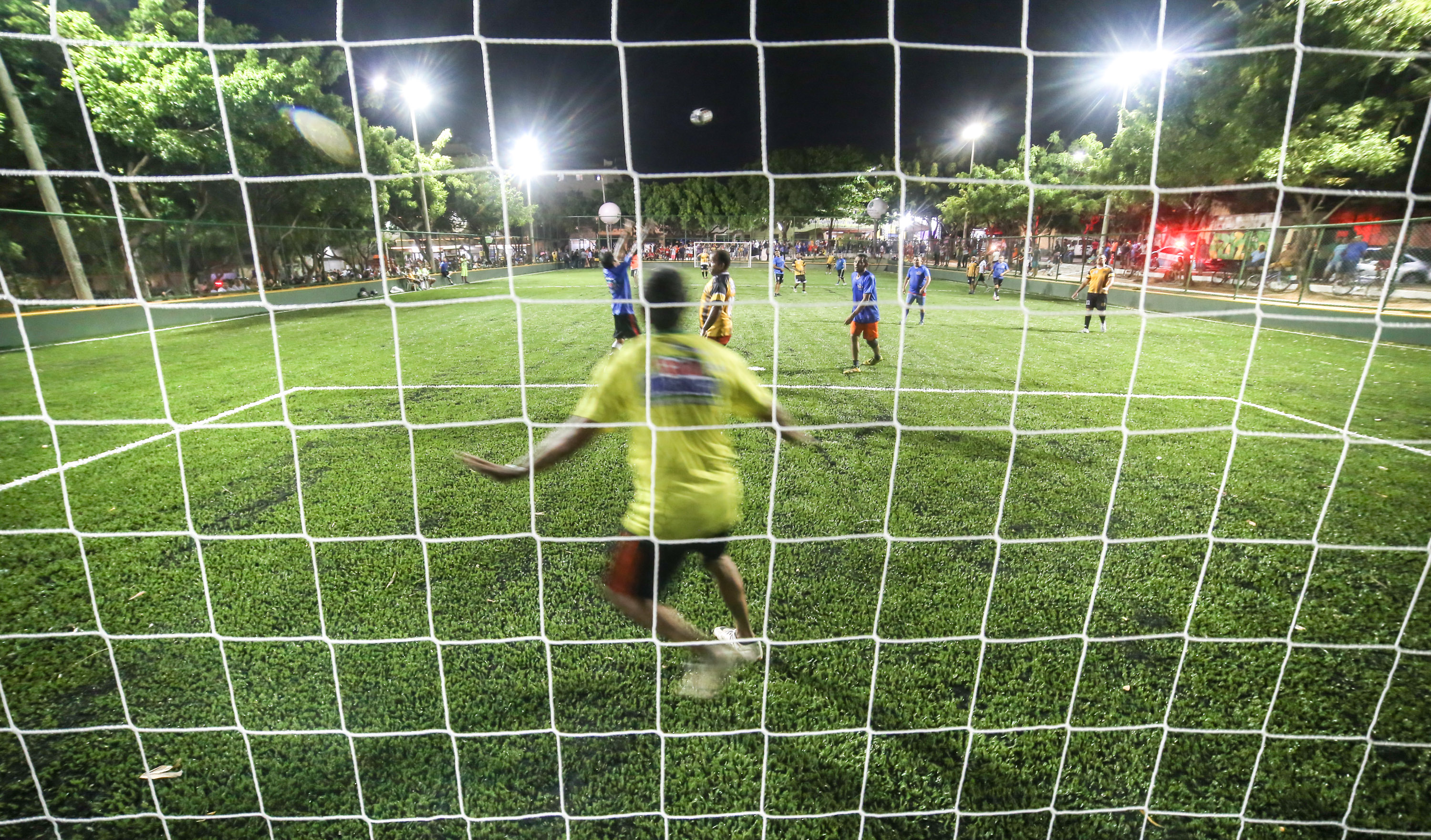 a foto mostra um gol no campo de futebol com um goleiro